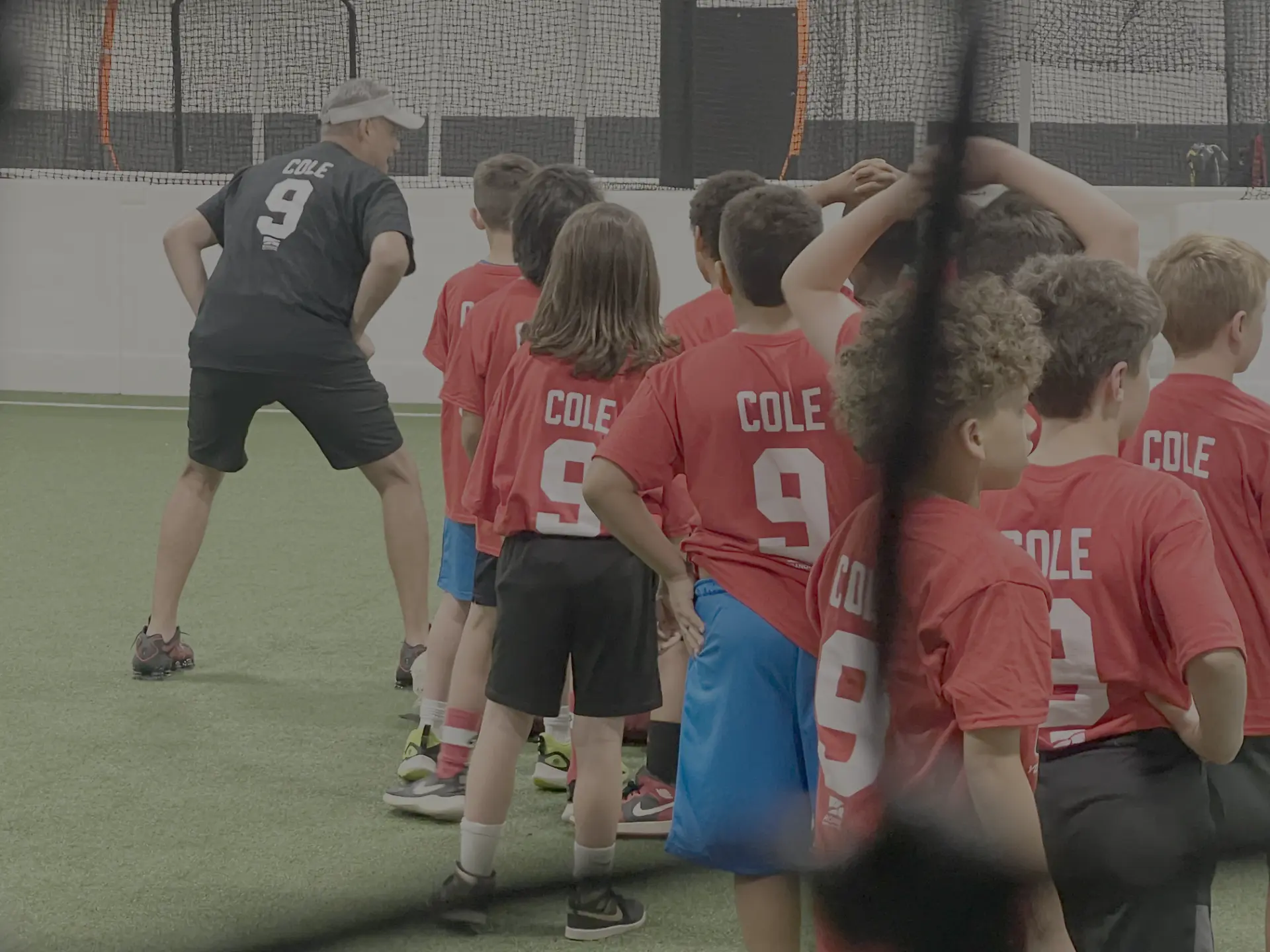 Campers in COLE 9 shirts lining up behind a coach for a drill