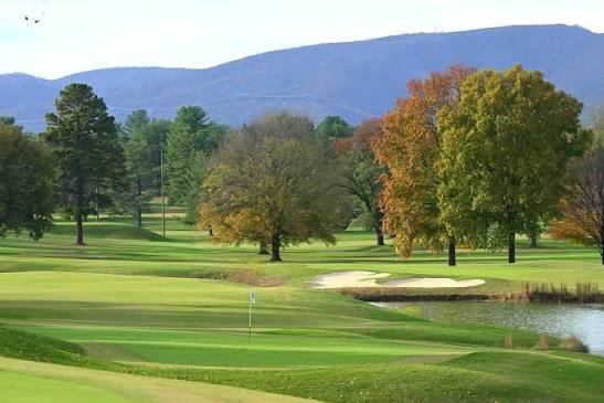 Golf course fairway and green with mountains in the background