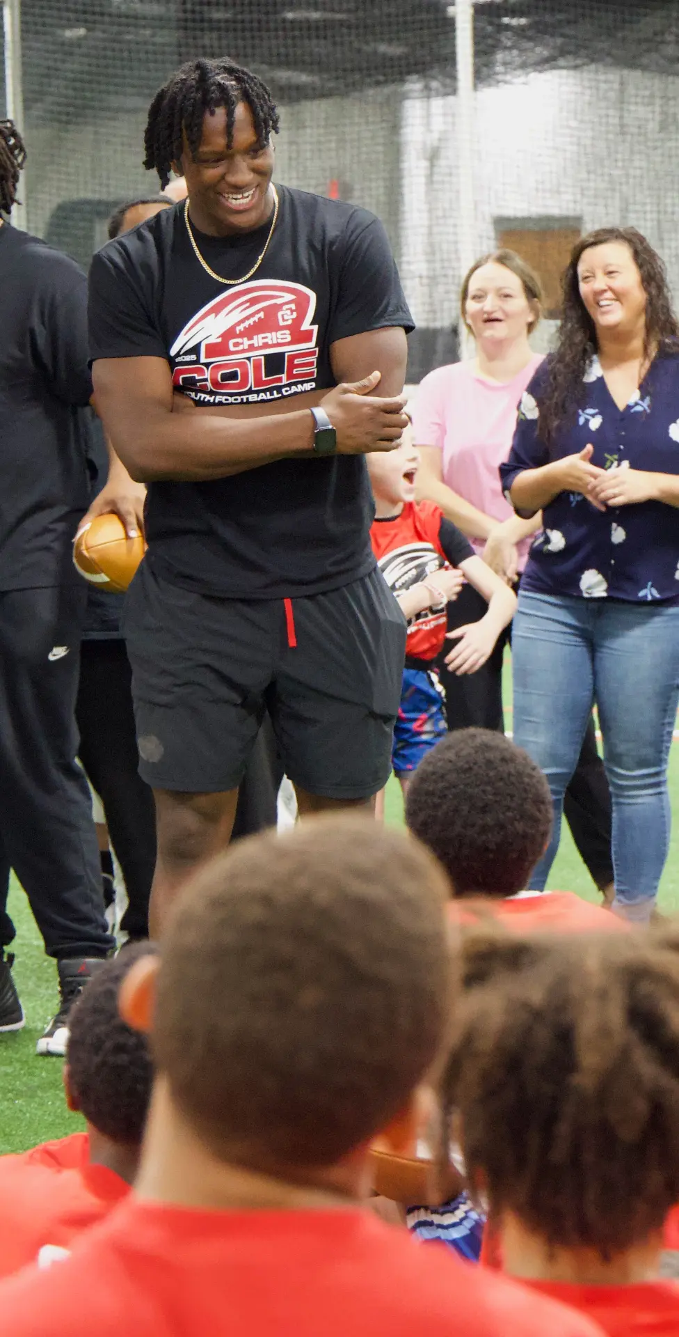 Chris Cole laughing with campers and parents during a camp drill