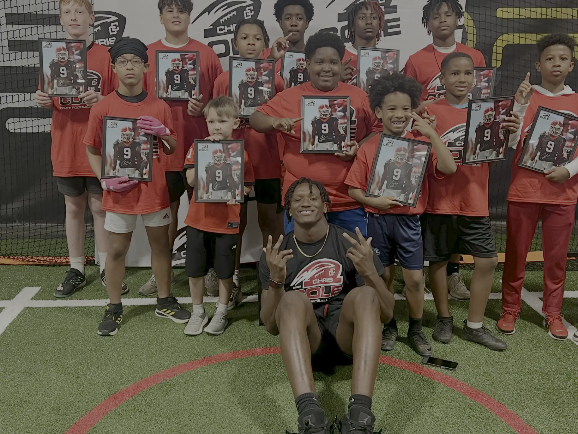 Campers holding signed photos with Chris Cole after the camp