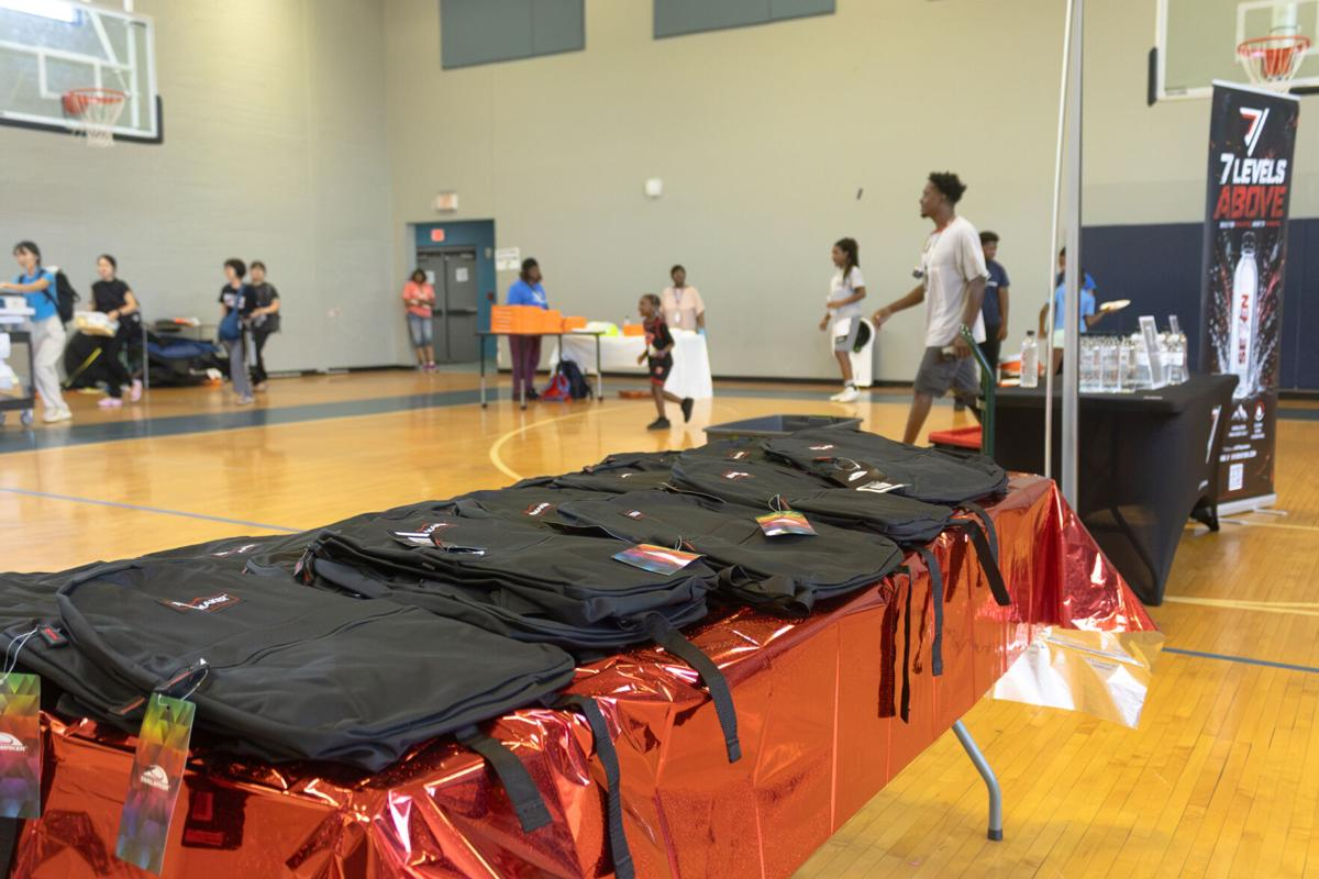 Volunteers packing school supplies into backpacks for students
